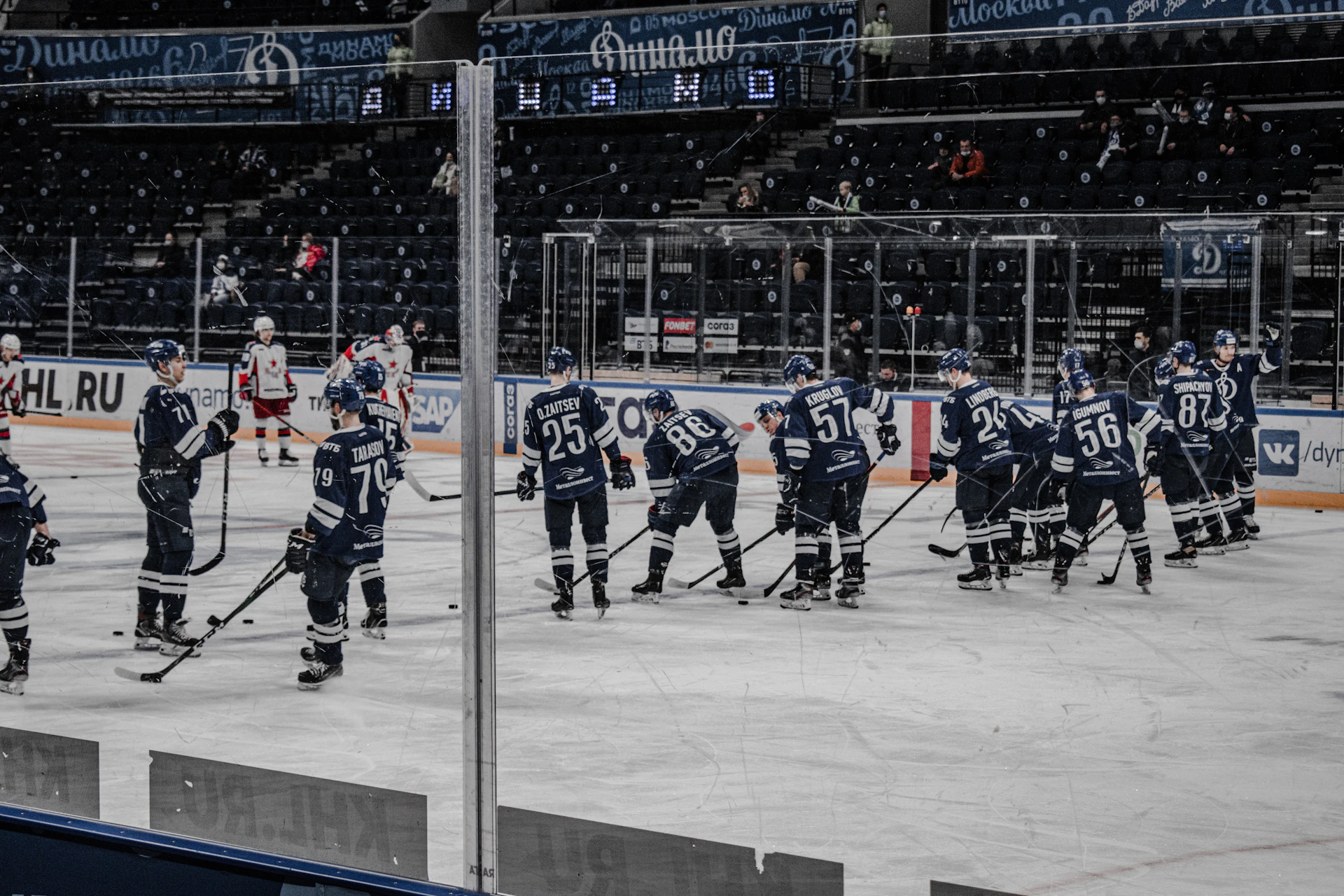 The team huddled together on the ice, their breath visible in the crisp air, sharing a quiet moment before a performance.