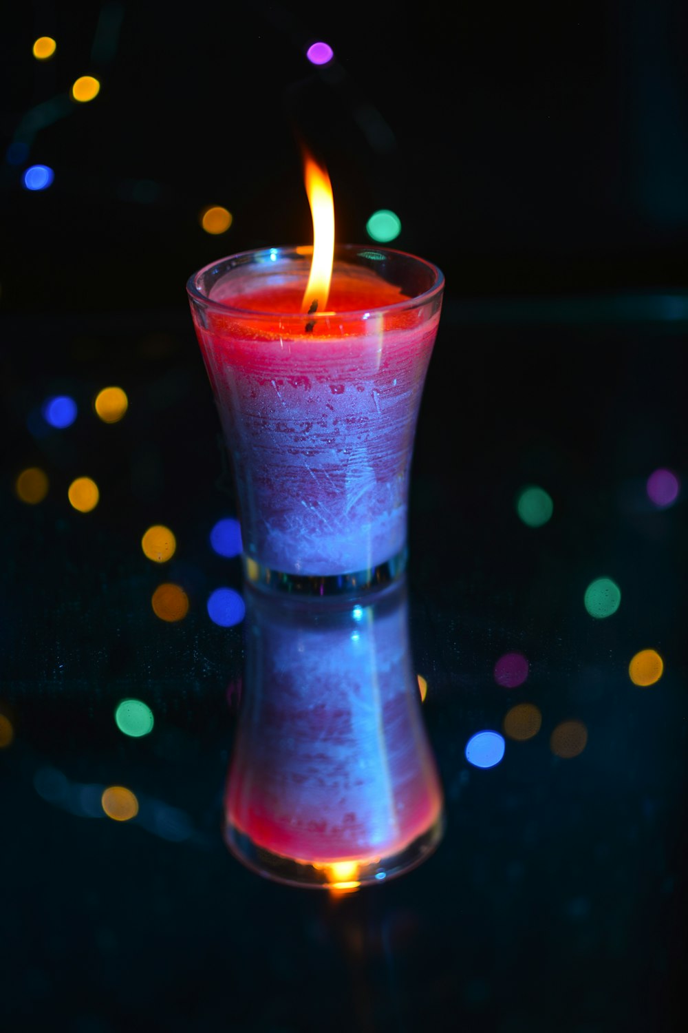 pink candle in clear glass bottle