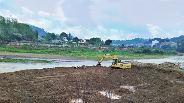 Excavator working on the sandy riverbank of Bío Bío under a clear sky.