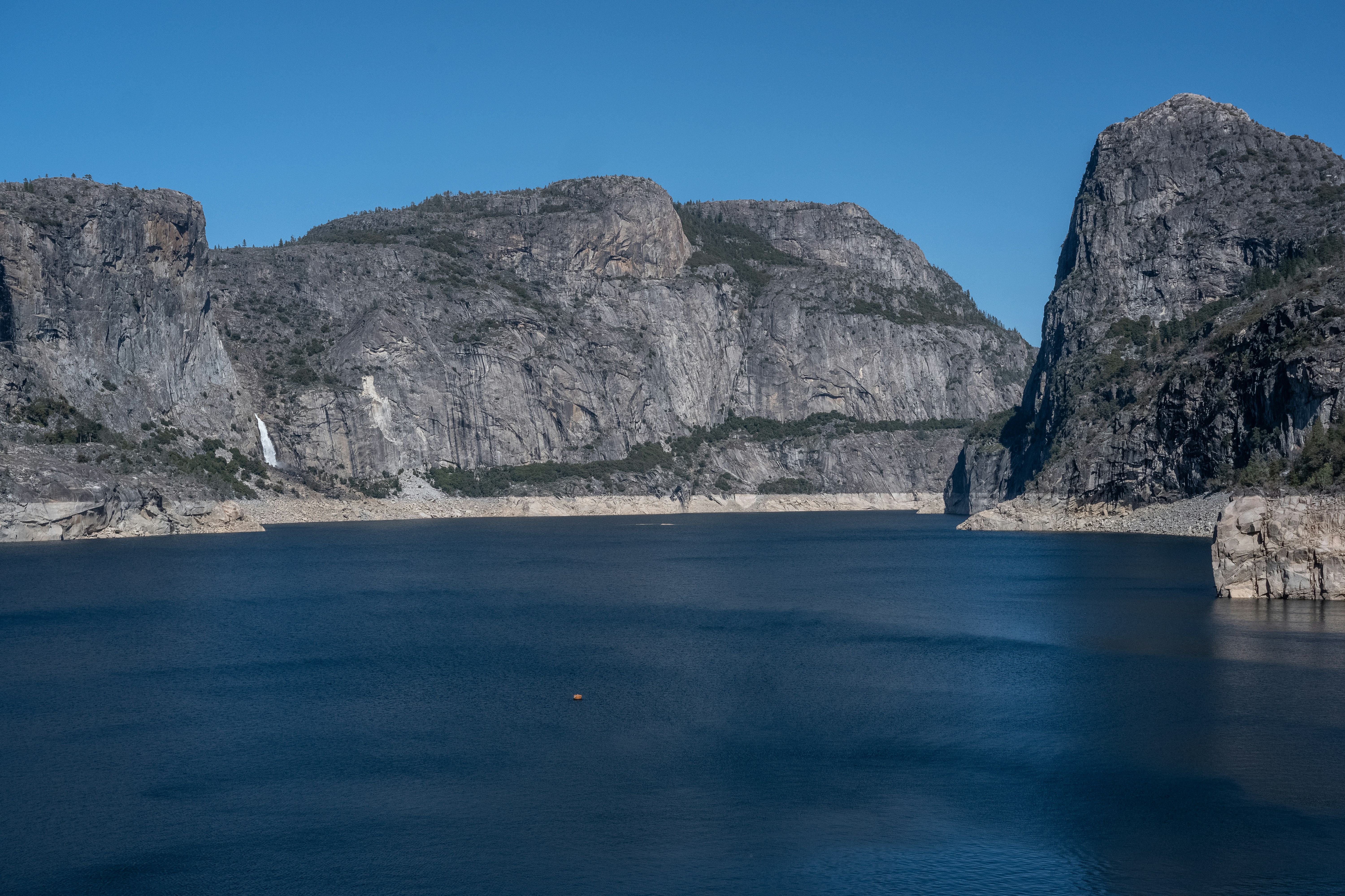 gray rocky mountain beside blue sea under blue sky during daytime, 