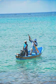 Couple enjoying a boat ride on crystal-clear turquoise waters.