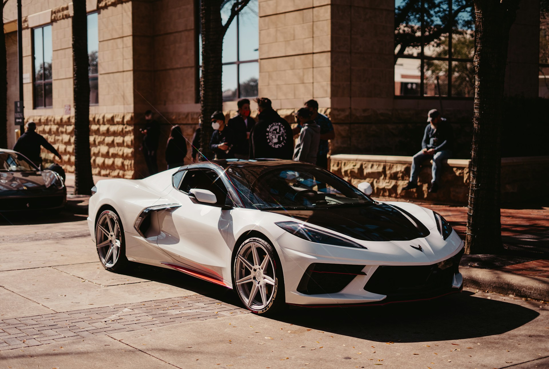 people standing beside white ferrari sports car
