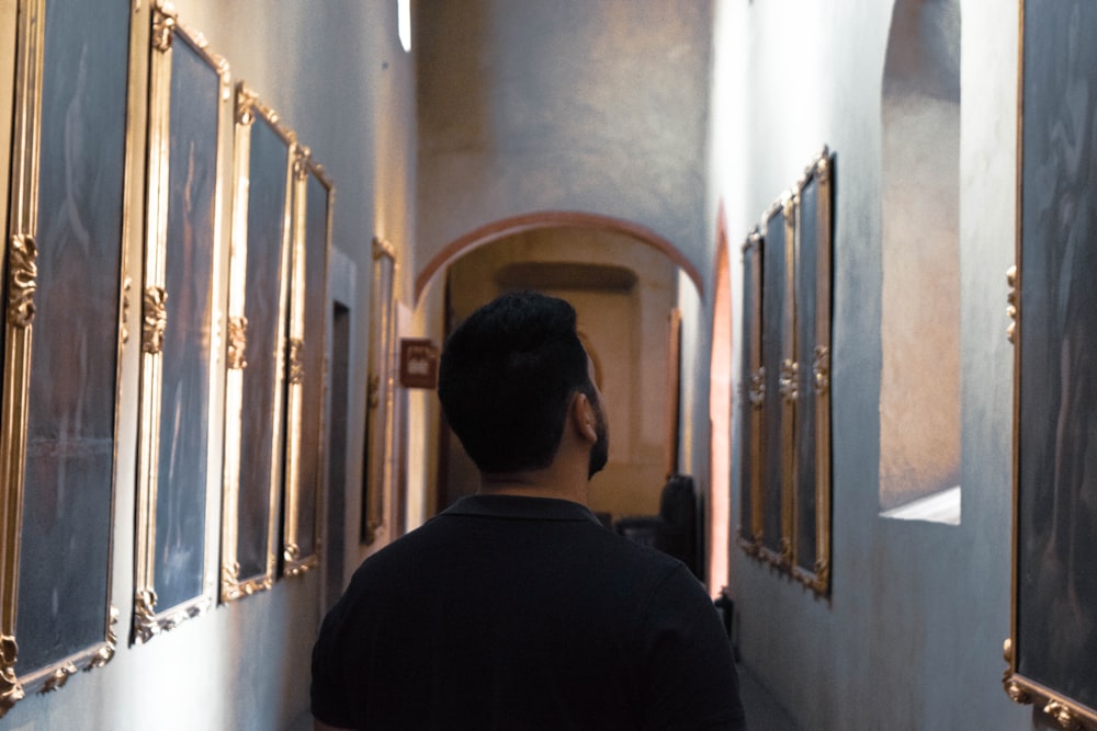 man in black shirt standing in hallway