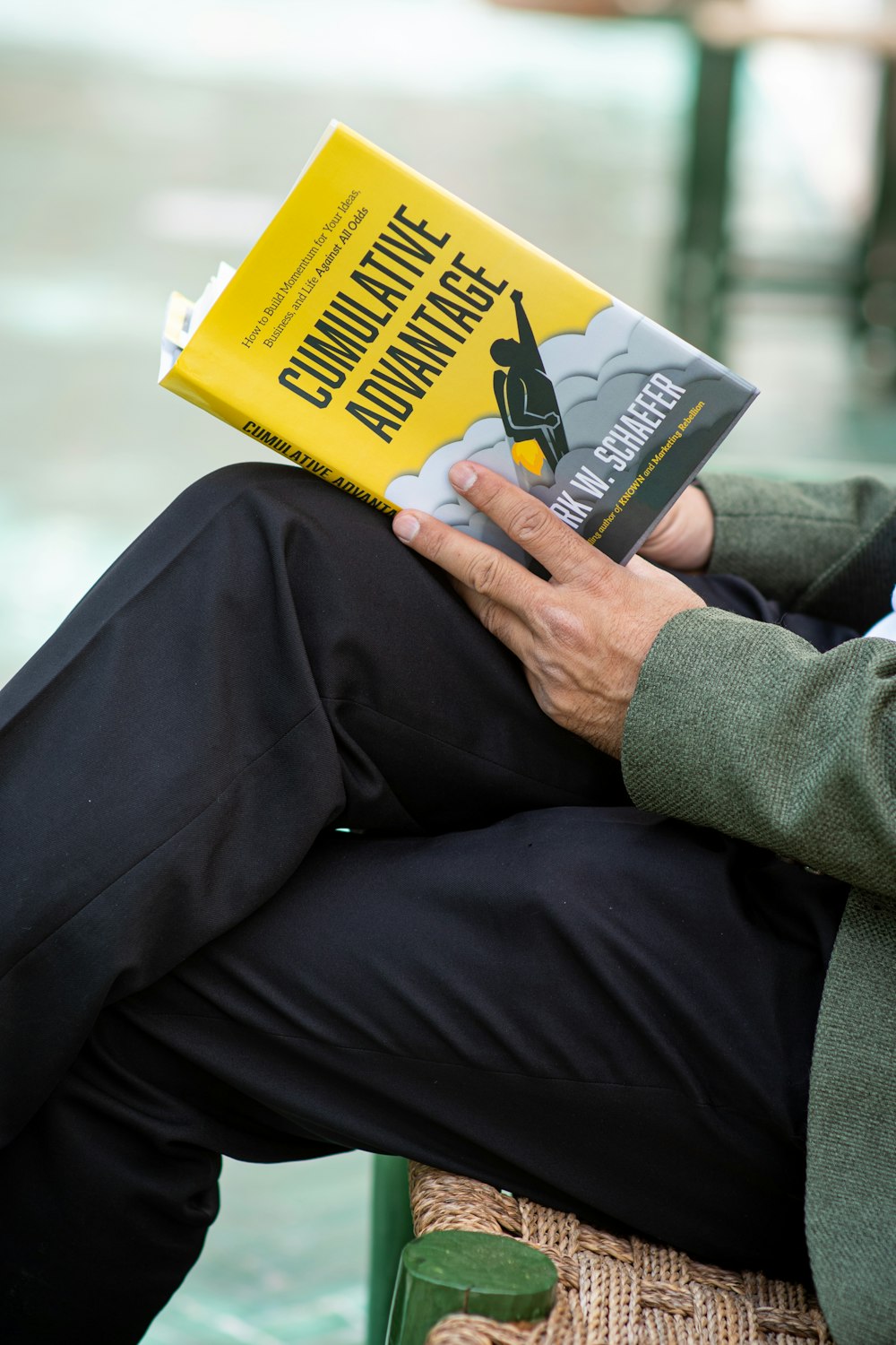 person in gray long sleeve shirt holding yellow book