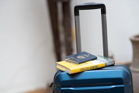 An elegant suitcase and passport arranged neatly on a clean white surface.