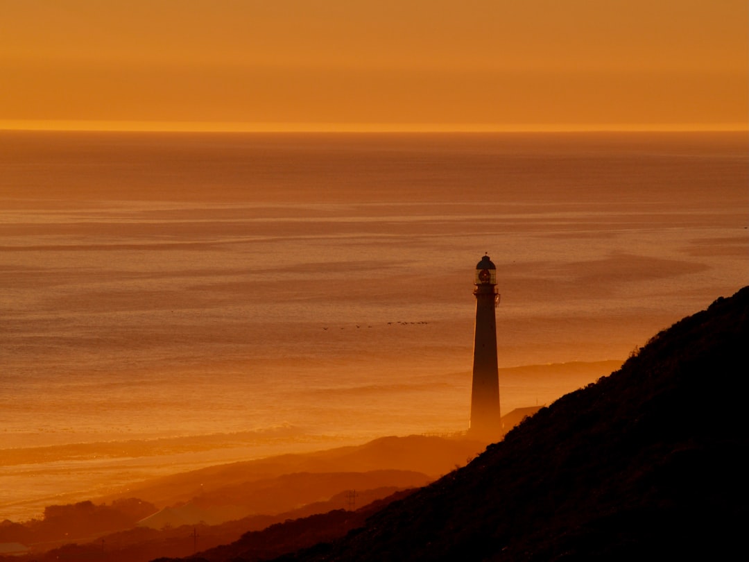 silhouette of lighthouse during sunset