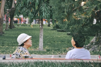 Two young people sitting on a park bench, engaged in a heartfelt conversation.
