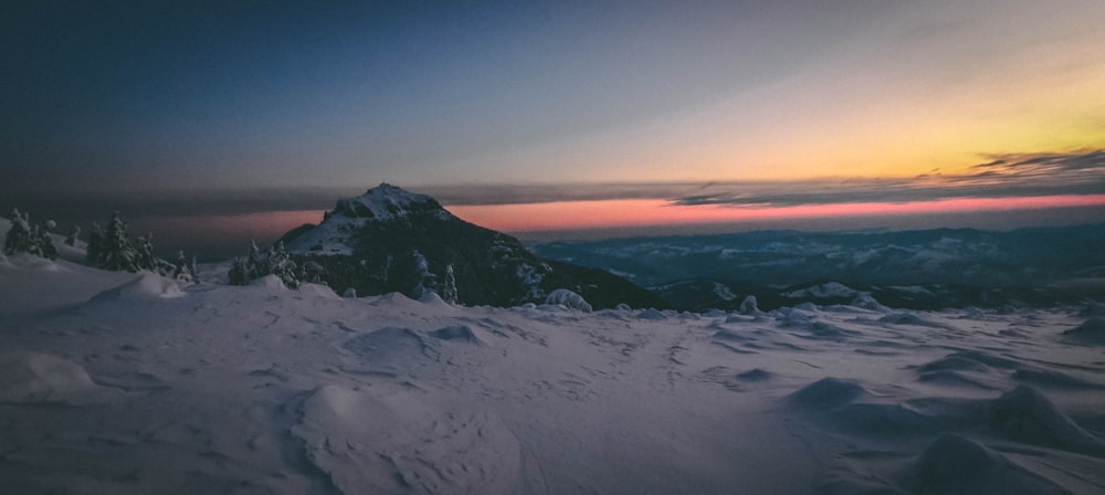 snow covered mountain during sunset