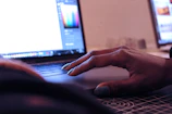 Close-up of hands interacting with a sleek SaaS interface on a laptop