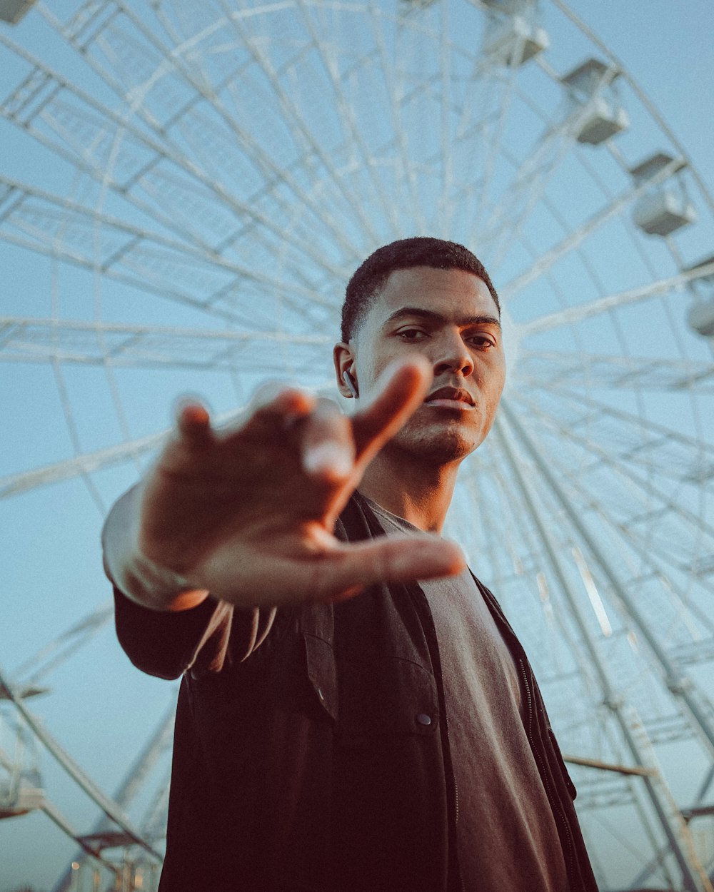 man in black leather jacket standing under white umbrella during daytime