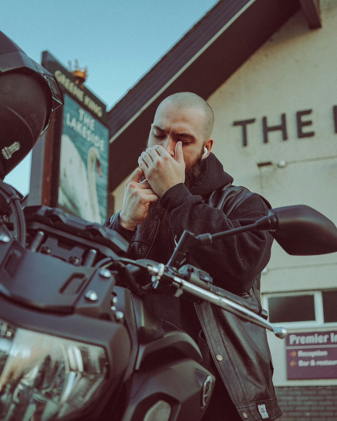 man in black jacket sitting on red motorcycle