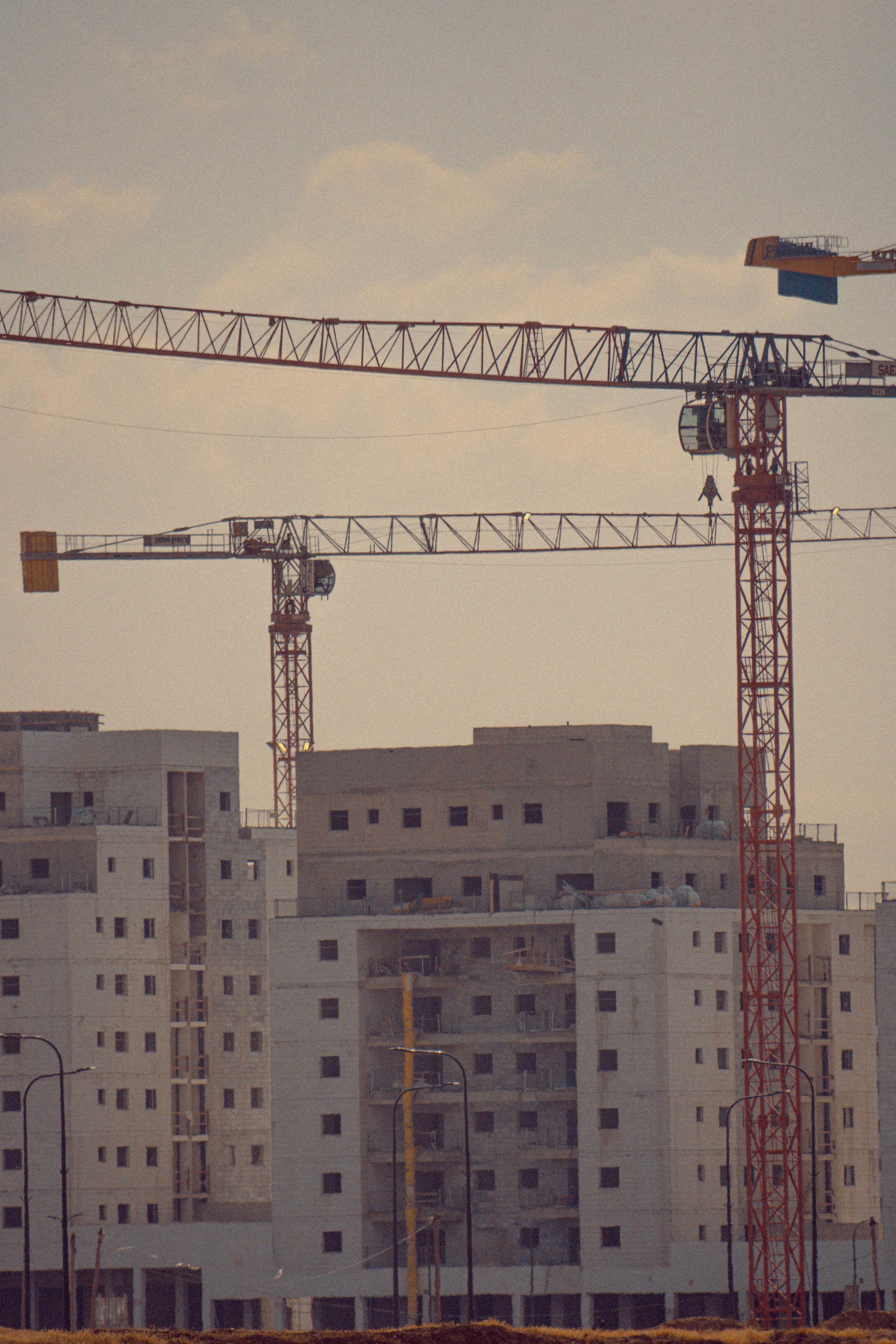 red and black crane near white concrete building during daytime