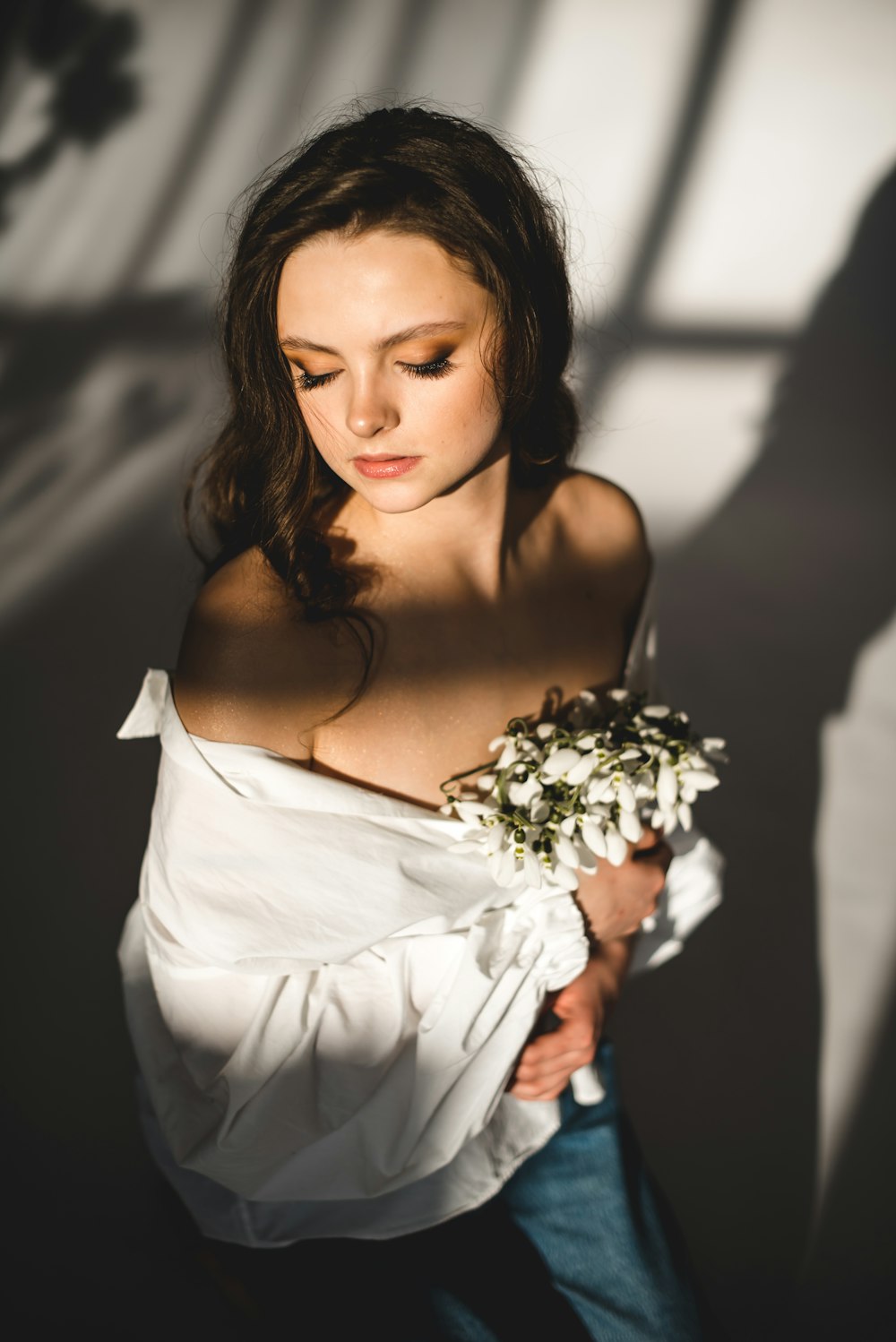 woman in white off shoulder dress holding white flower bouquet