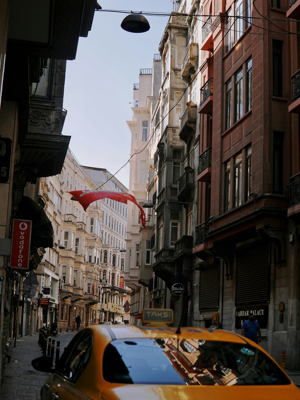 cars parked on side of the road in between buildings during daytime