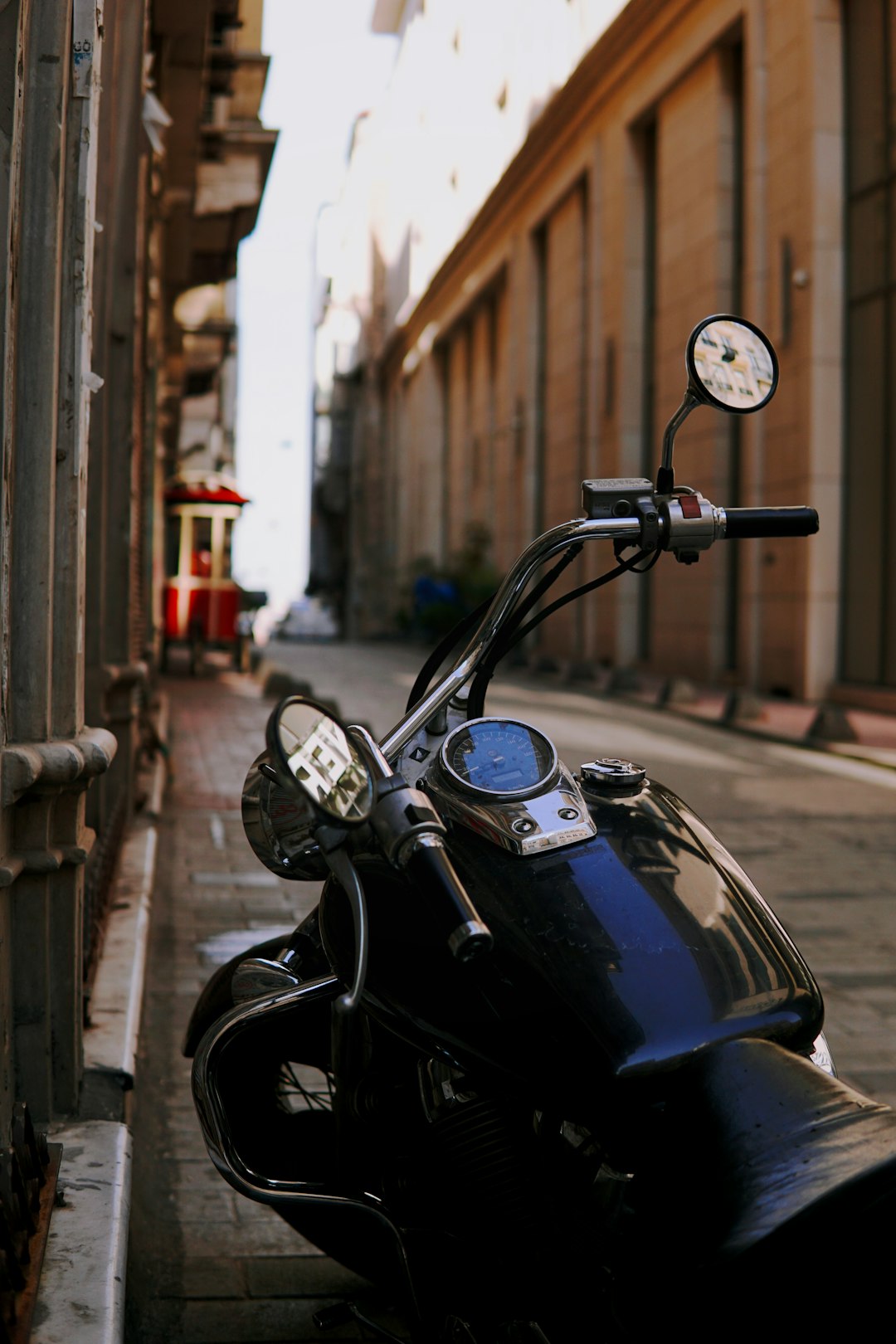 black motorcycle parked beside the road during daytime