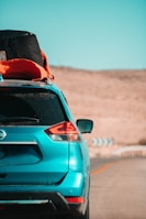 A spacious rental SUV loaded with luggage driving along a scenic outback road.