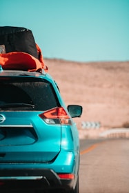 A family enjoying a road trip in an SUV with luggage on the roof rack.