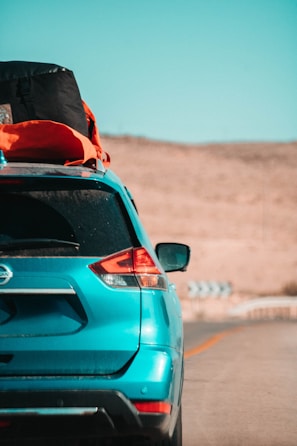 A spacious rental SUV loaded with luggage driving along a scenic outback road.