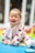 A joyful baby surrounded by soft baby essentials.