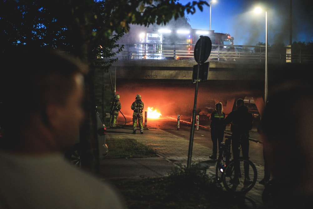 people standing on sidewalk during night time