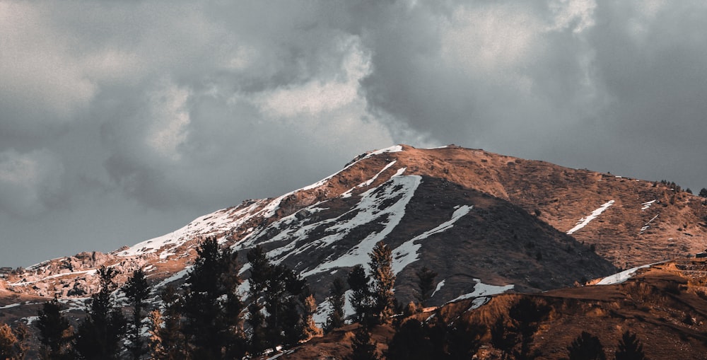 brown and white mountain under white clouds during daytime