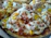 Close-up of a sizzling Mexican breakfast pizza topped with fresh jalapeños and melted cheese.