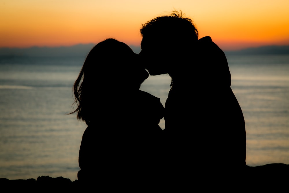 silhouette of couple kissing during sunset