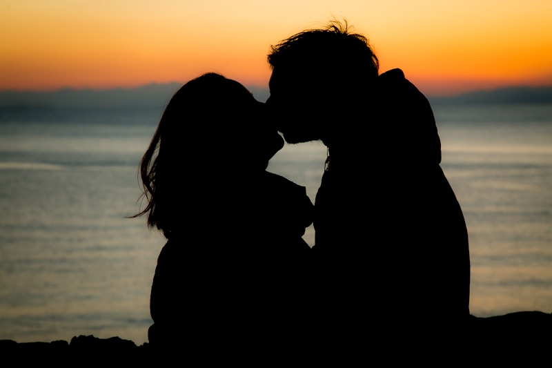 Sunset silhouette kiss by the sea
