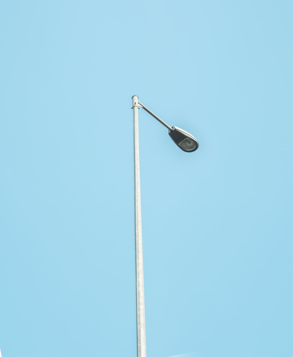 lampadaire noir sous le ciel bleu pendant la journée