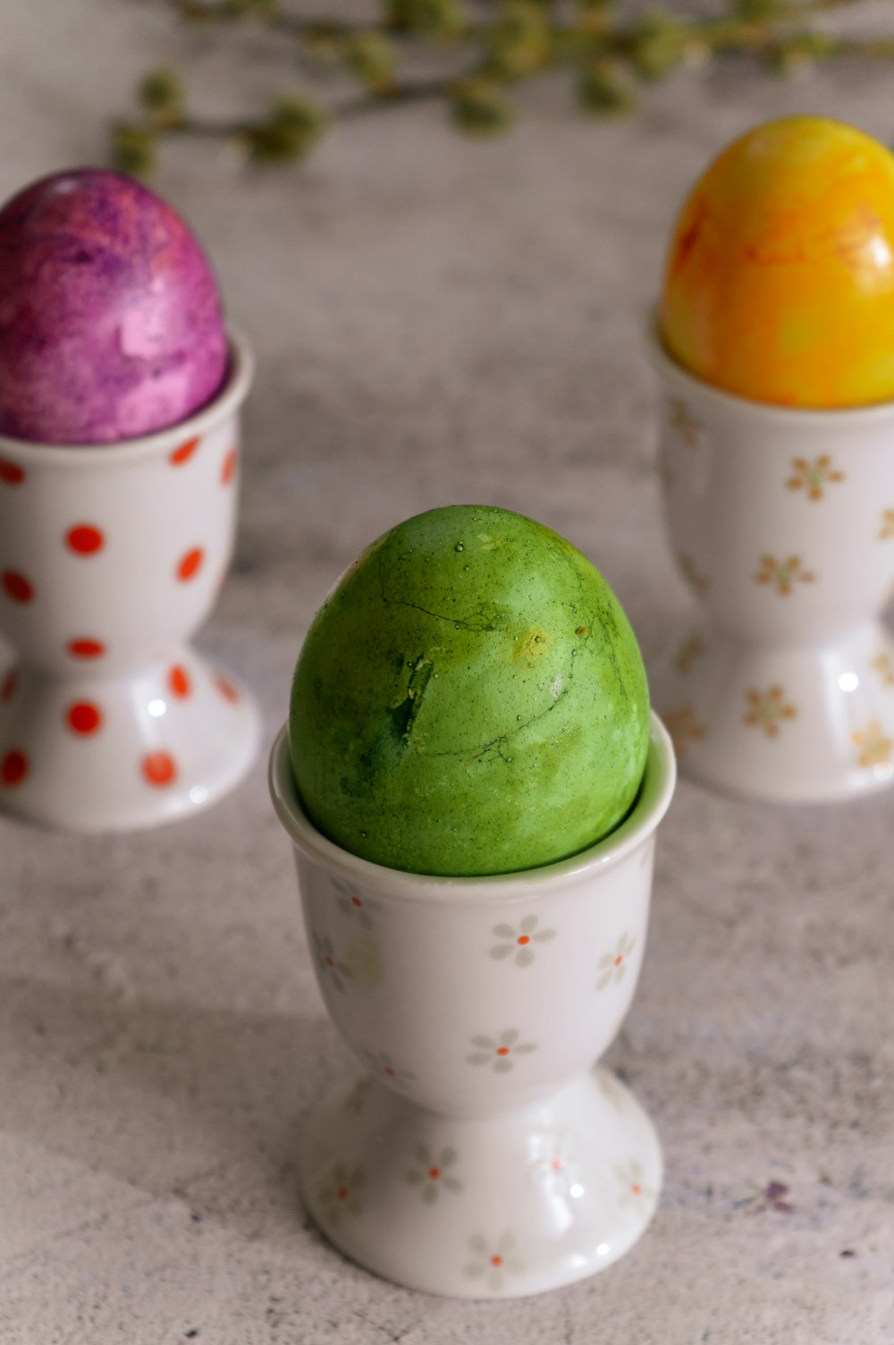 three small cups with different colored balls in them