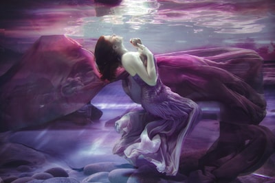 woman in white dress sitting on rock