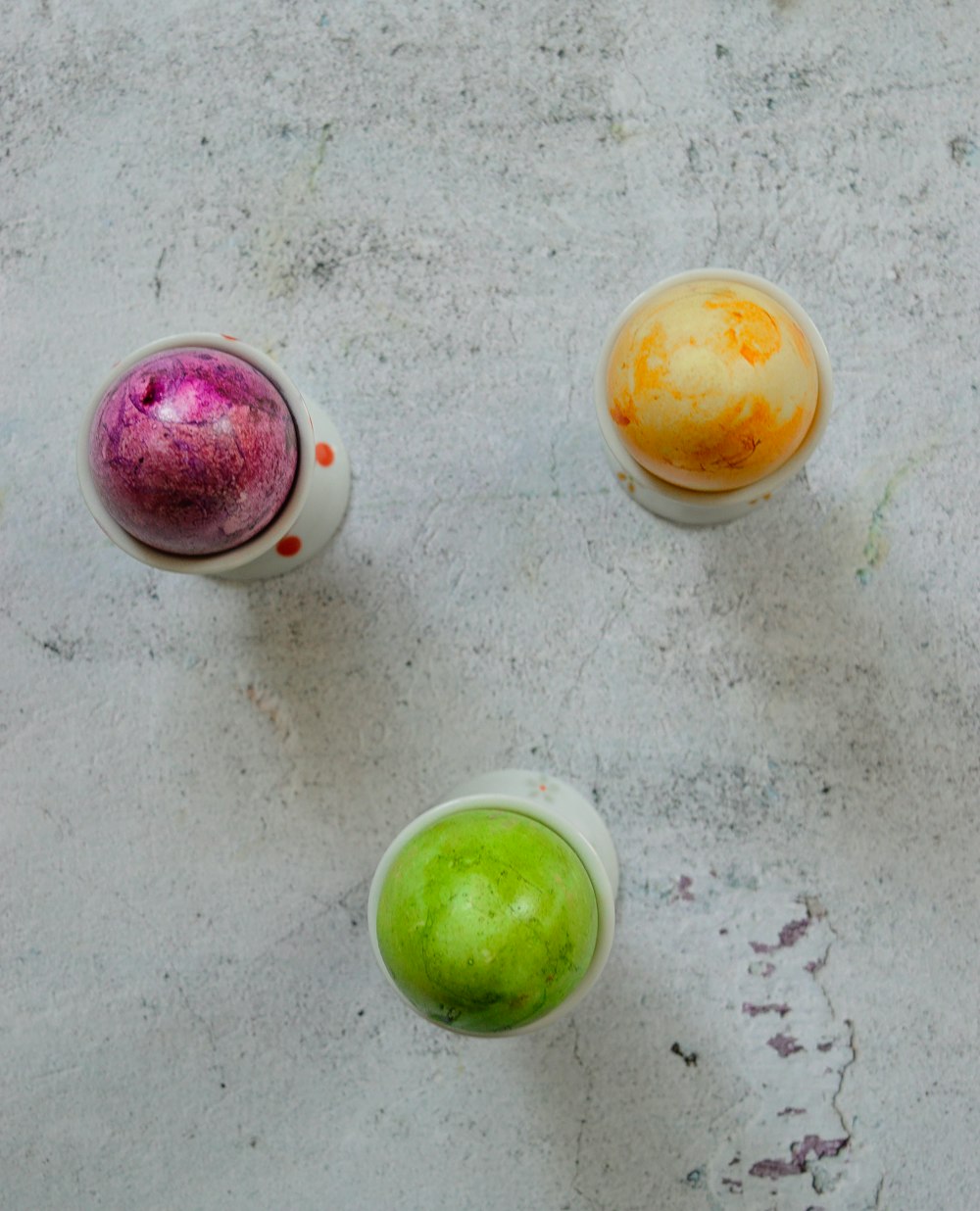 a group of three different colored eggs sitting next to each other