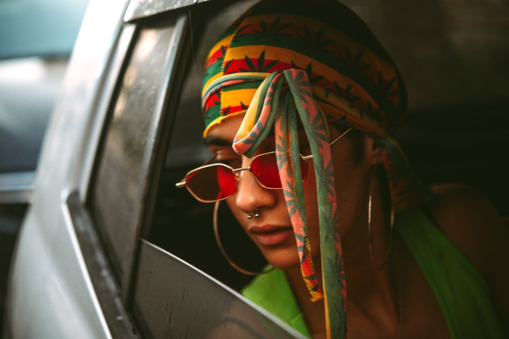 a woman wearing a colorful head scarf and sunglasses