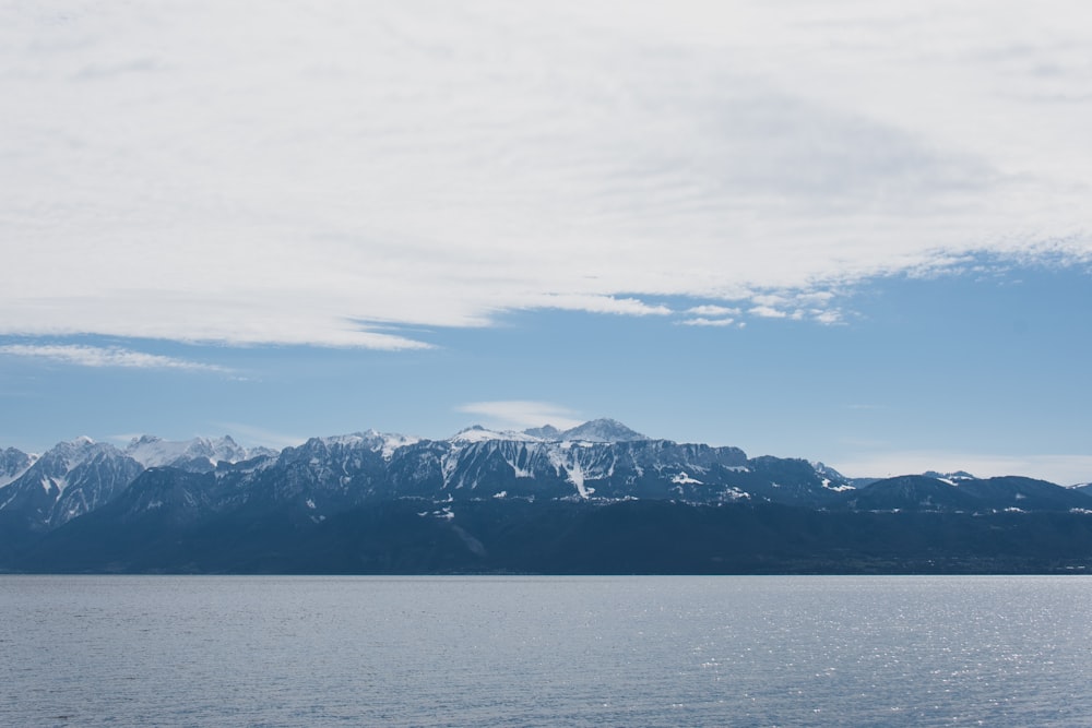 snow covered mountain near body of water during daytime