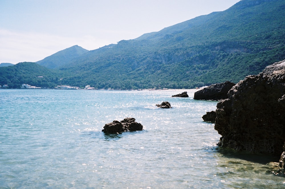 black rock formation on body of water during daytime