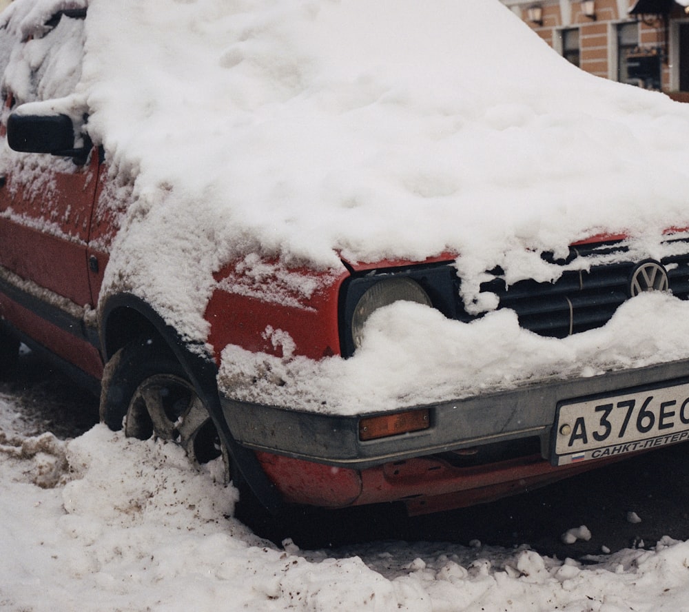 red and white chevrolet car covered with snow