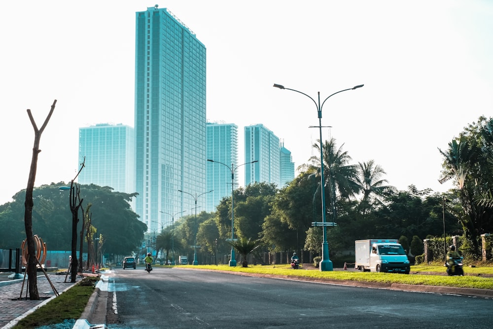 Coches aparcados a un lado de la carretera cerca de un edificio de gran altura durante el día