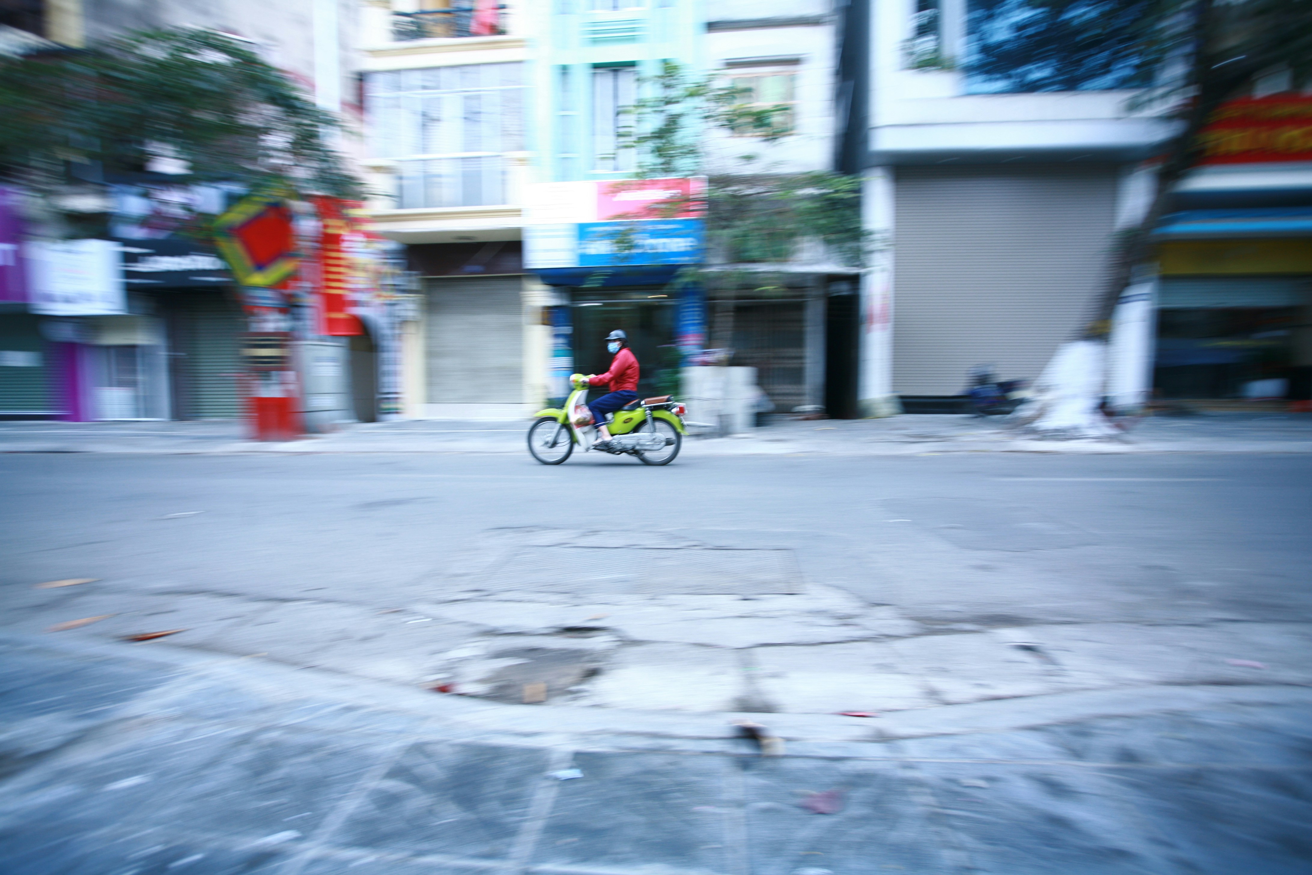 man in red jacket riding bicycle on street during daytime