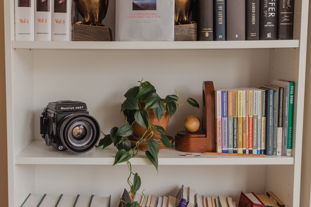 black nikon camera on white wooden shelf