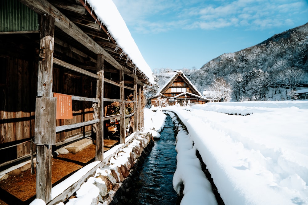 brown wooden house on snow covered ground near mountain during daytime