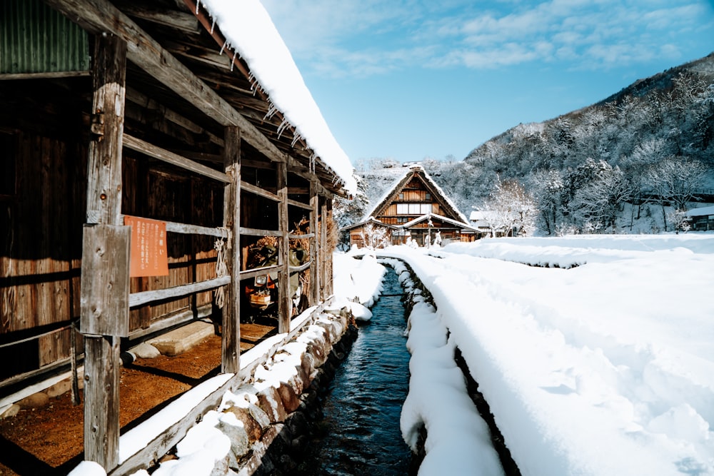 Braunes Holzhaus auf schneebedecktem Boden in der Nähe des Berges tagsüber