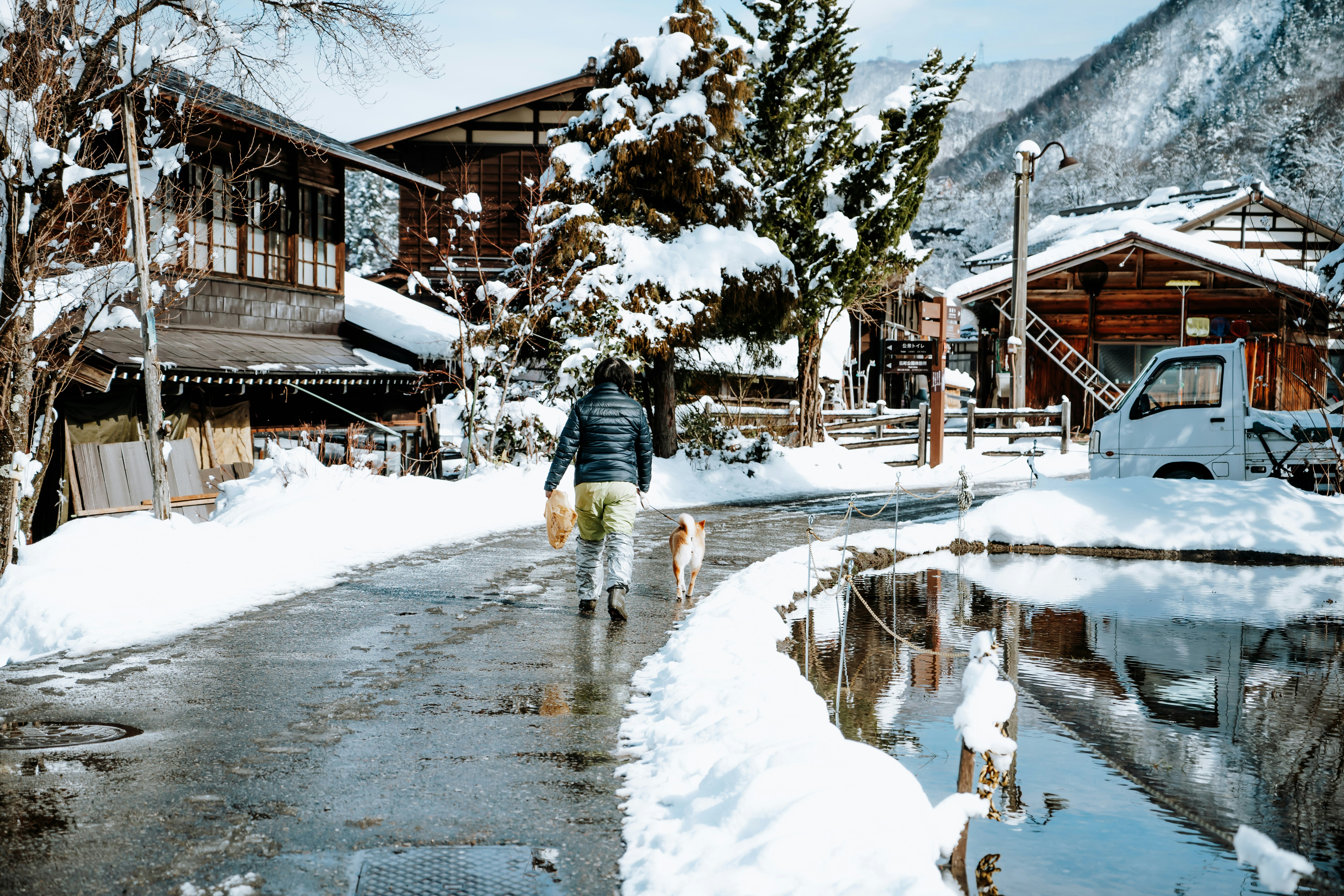 Person wearing layered winter clothing and waterproof boots in snowy Japan