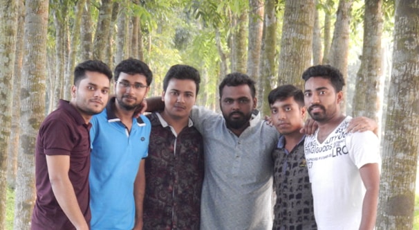 An outdoor group shot of lodge brothers planting a tree during a community service event.