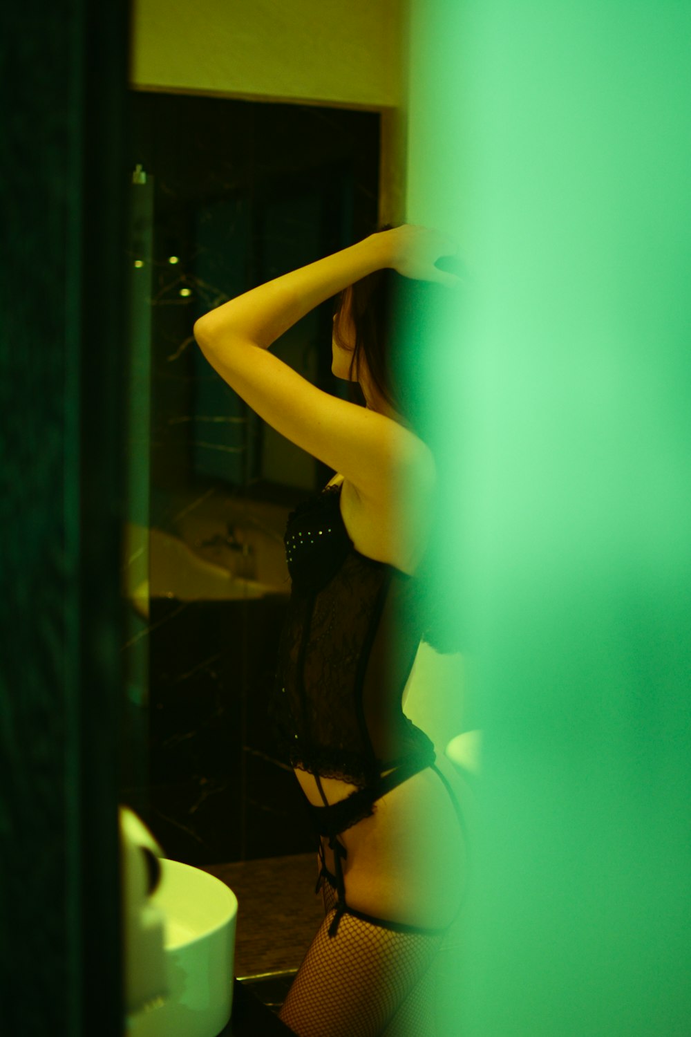 woman in black lingerie standing in front of glass window
