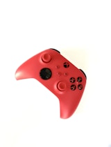 A vibrant red gaming controller featuring black buttons and directional sticks. The controller has an ergonomic design and appears to be for a modern gaming console, possibly an Xbox.