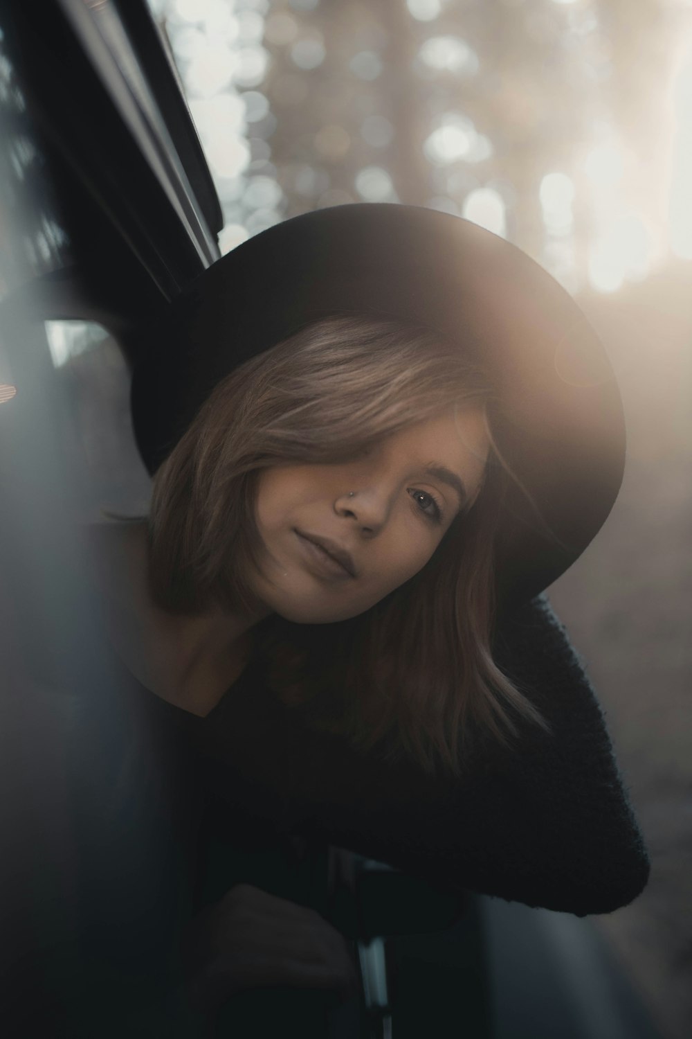 woman in black coat sitting inside car during daytime