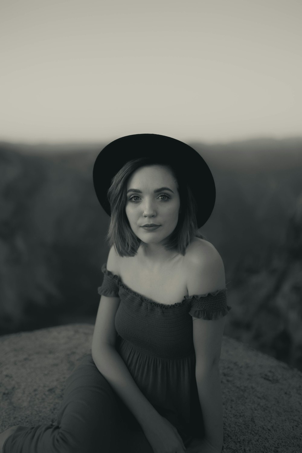 woman in black off shoulder dress wearing black hat