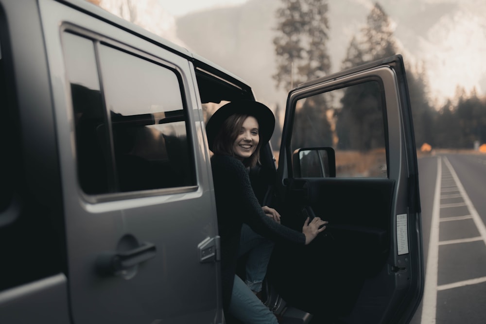 2 women sitting on car