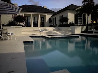A sleek rectangular pool with integrated lighting at dusk.