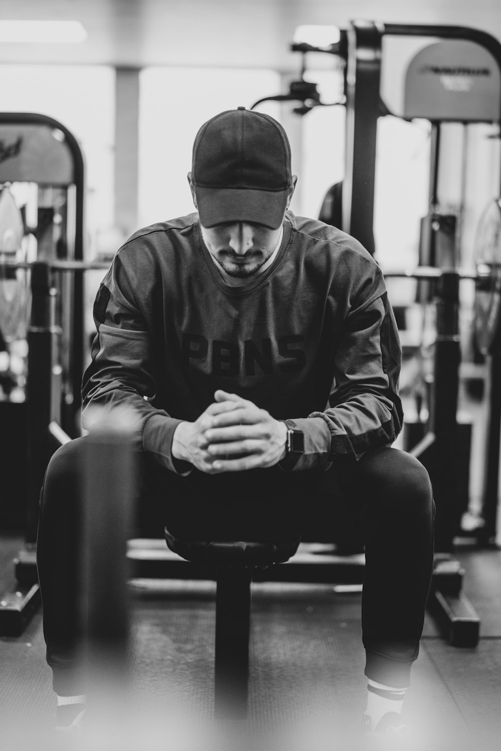 man in black jacket and knit cap sitting on bench